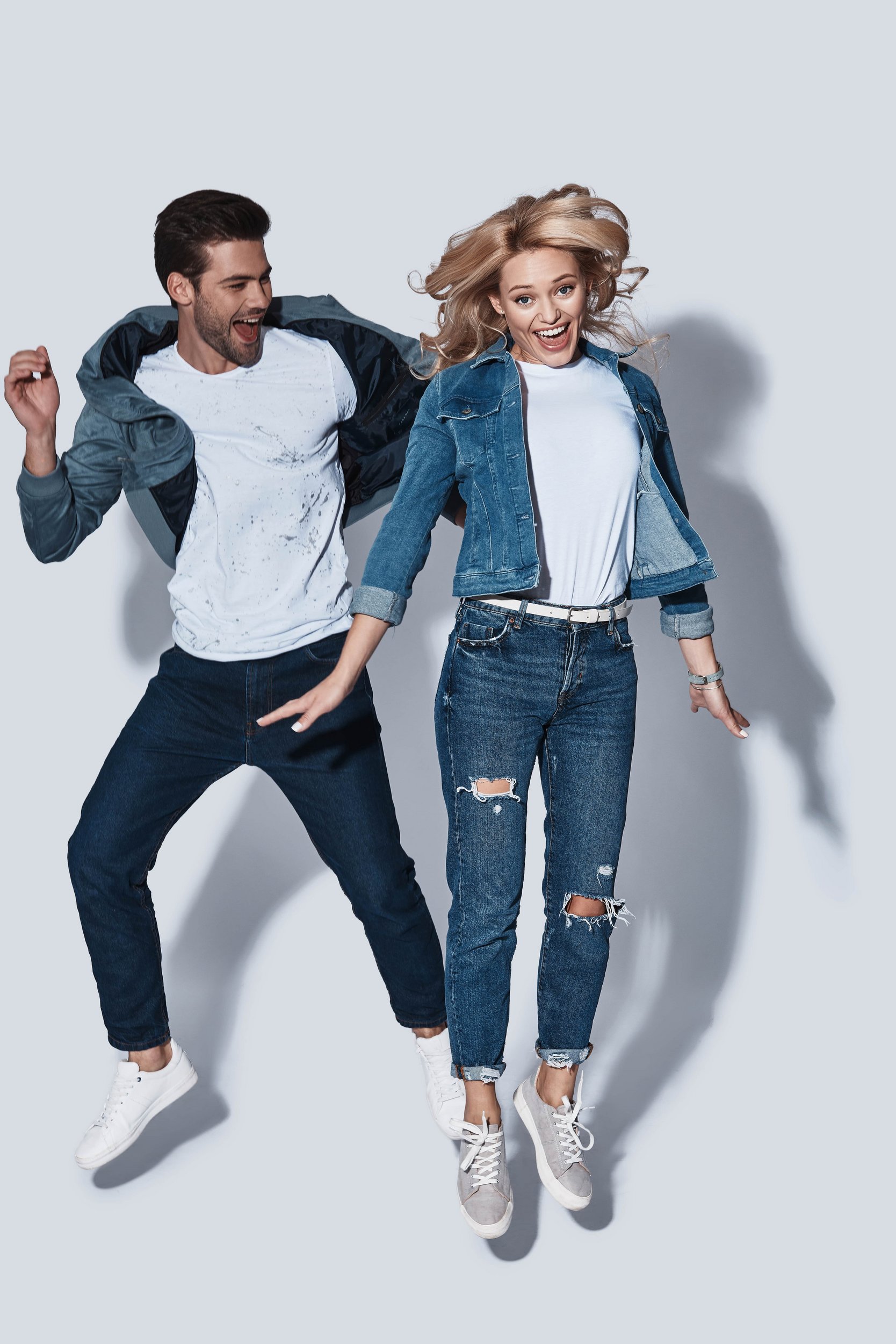 Jumping couple wearing jeans an t-shirts